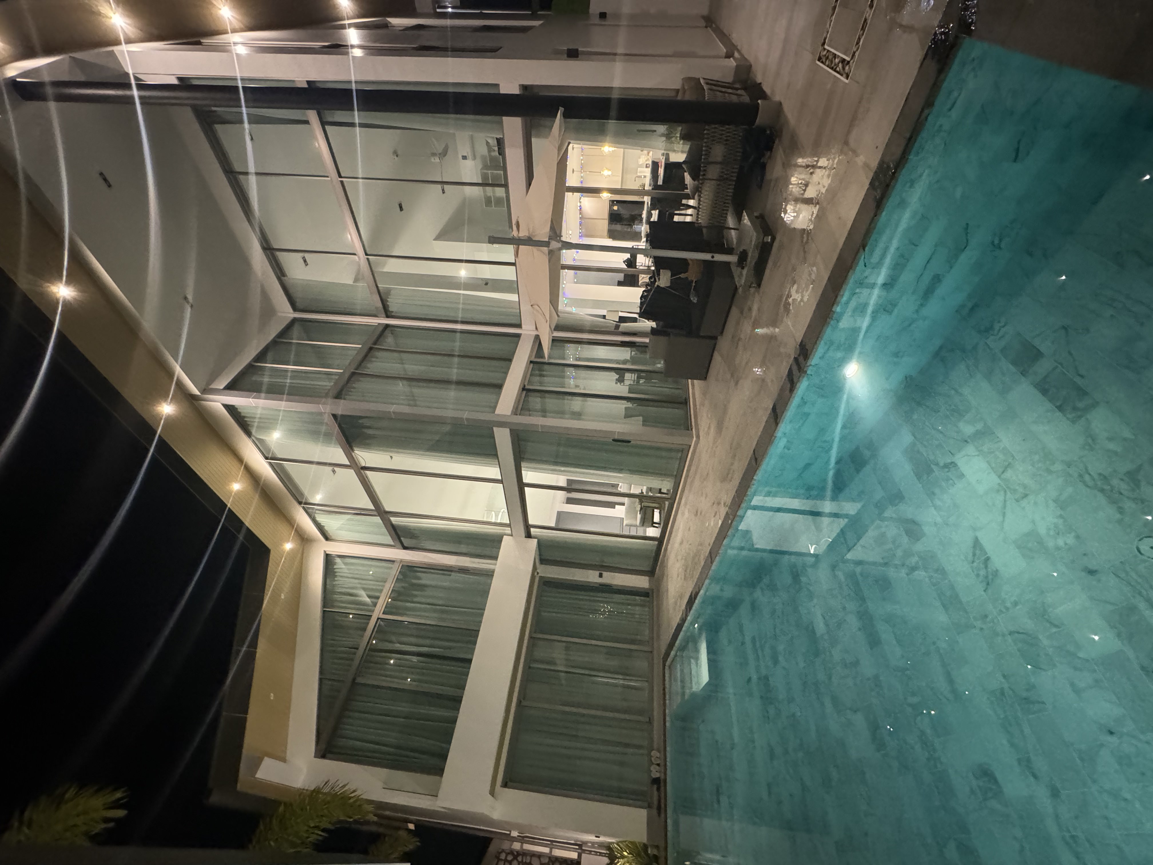 Stunning nighttime exterior view of the modern villa with illuminated pool